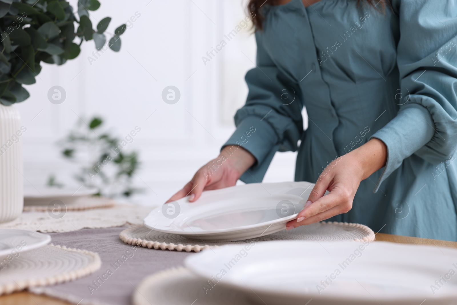 Photo of Woman setting table for dinner at home, closeup