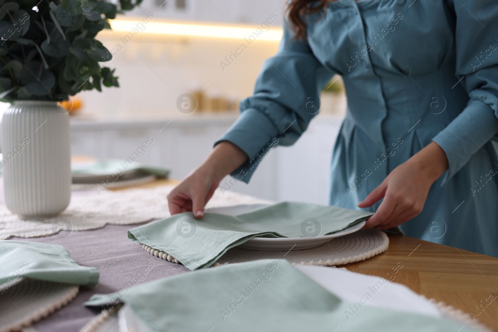 Photo of Woman setting table for dinner at home, closeup