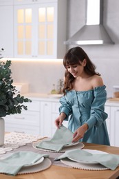 Photo of Woman setting table for dinner at home