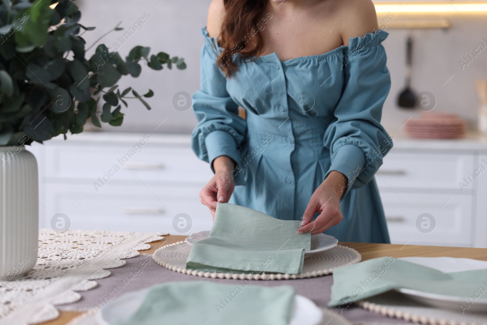 Photo of Woman setting table for dinner at home, closeup