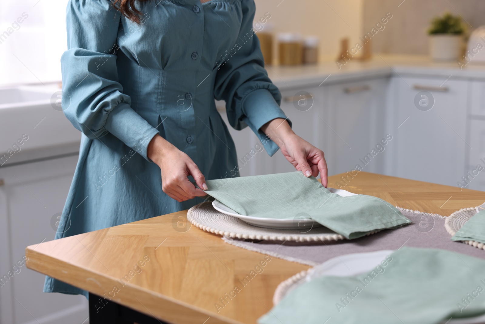 Photo of Woman setting table for dinner at home, closeup