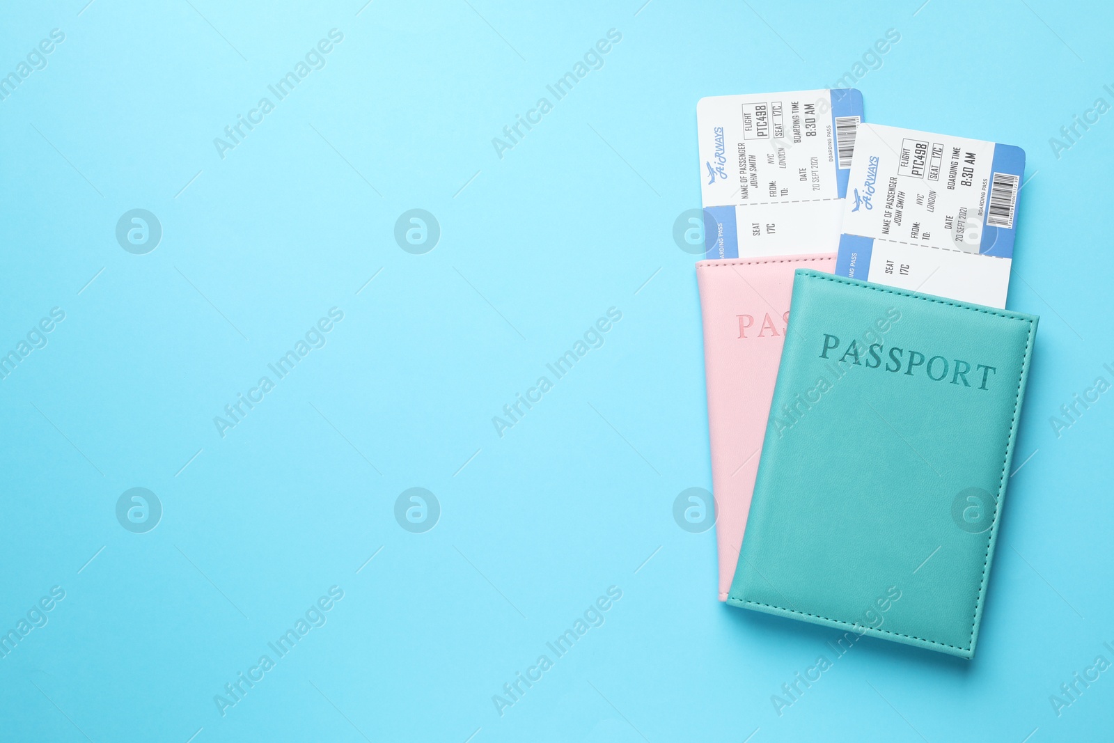 Photo of Travel agency. Flight tickets and passports on light blue background, top view. Space for text