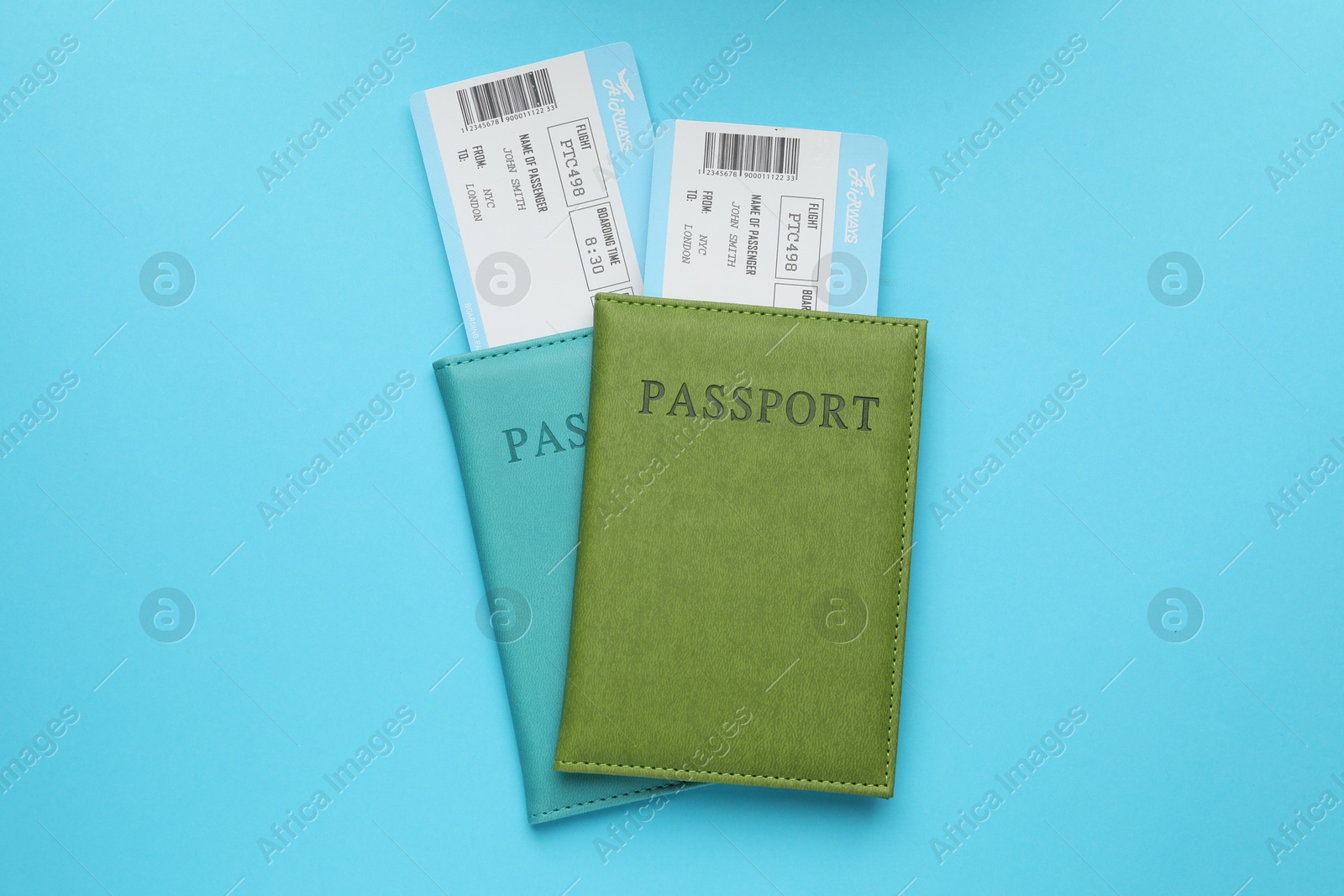 Photo of Travel agency. Flight tickets and passports on light blue background, top view