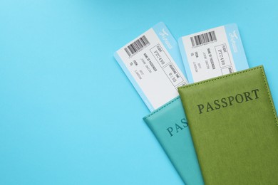 Photo of Travel agency. Flight tickets and passports on light blue background, top view. Space for text