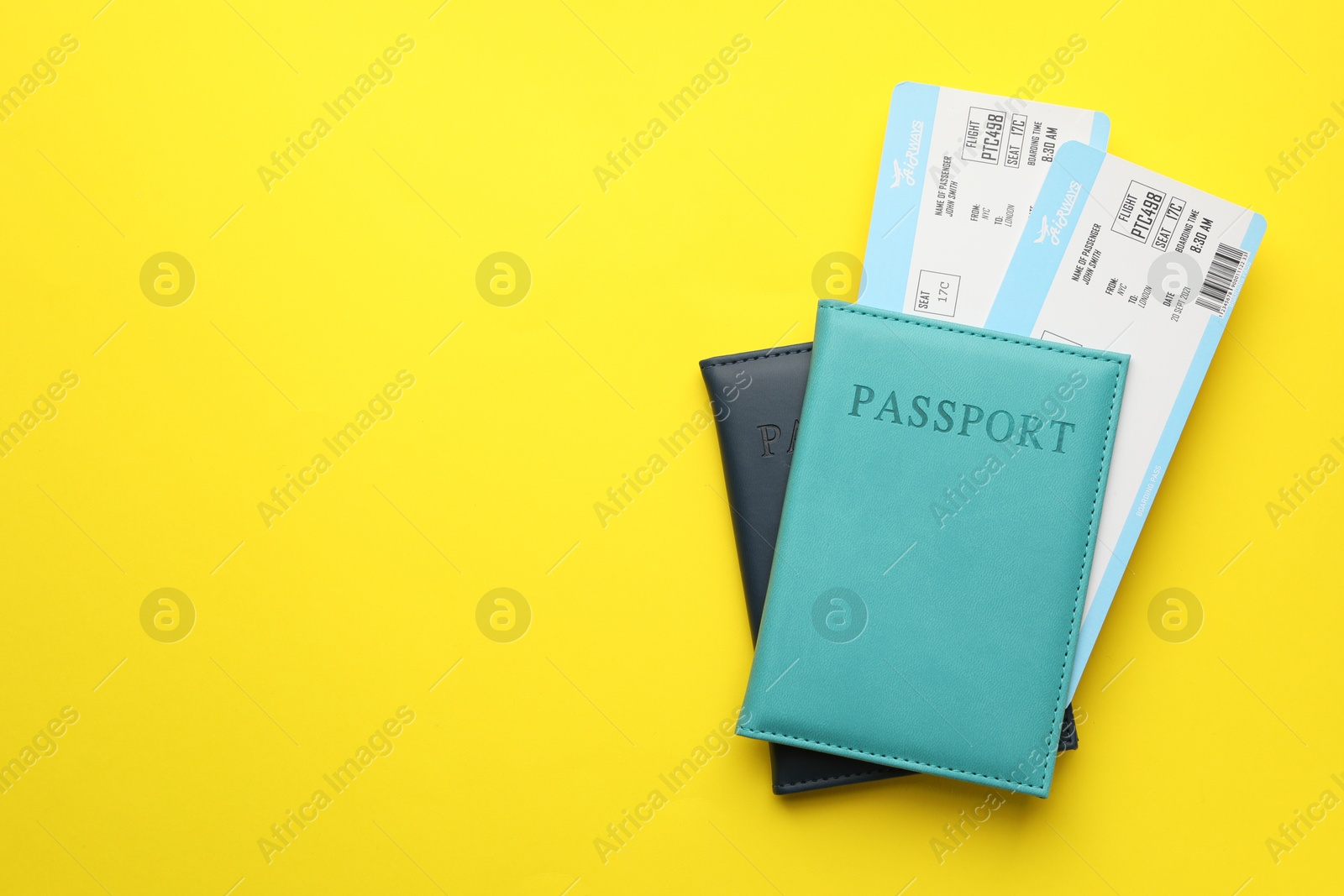 Photo of Travel agency. Flight tickets and passports on yellow background, top view. Space for text