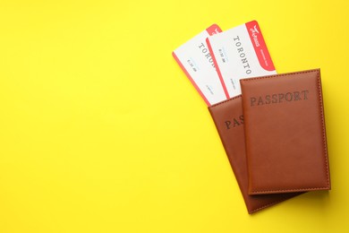 Photo of Travel agency. Flight tickets and passports on yellow background, top view. Space for text