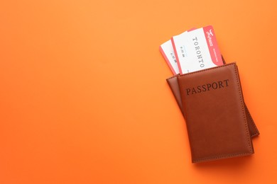 Photo of Travel agency. Flight tickets and passports on orange background, top view. Space for text