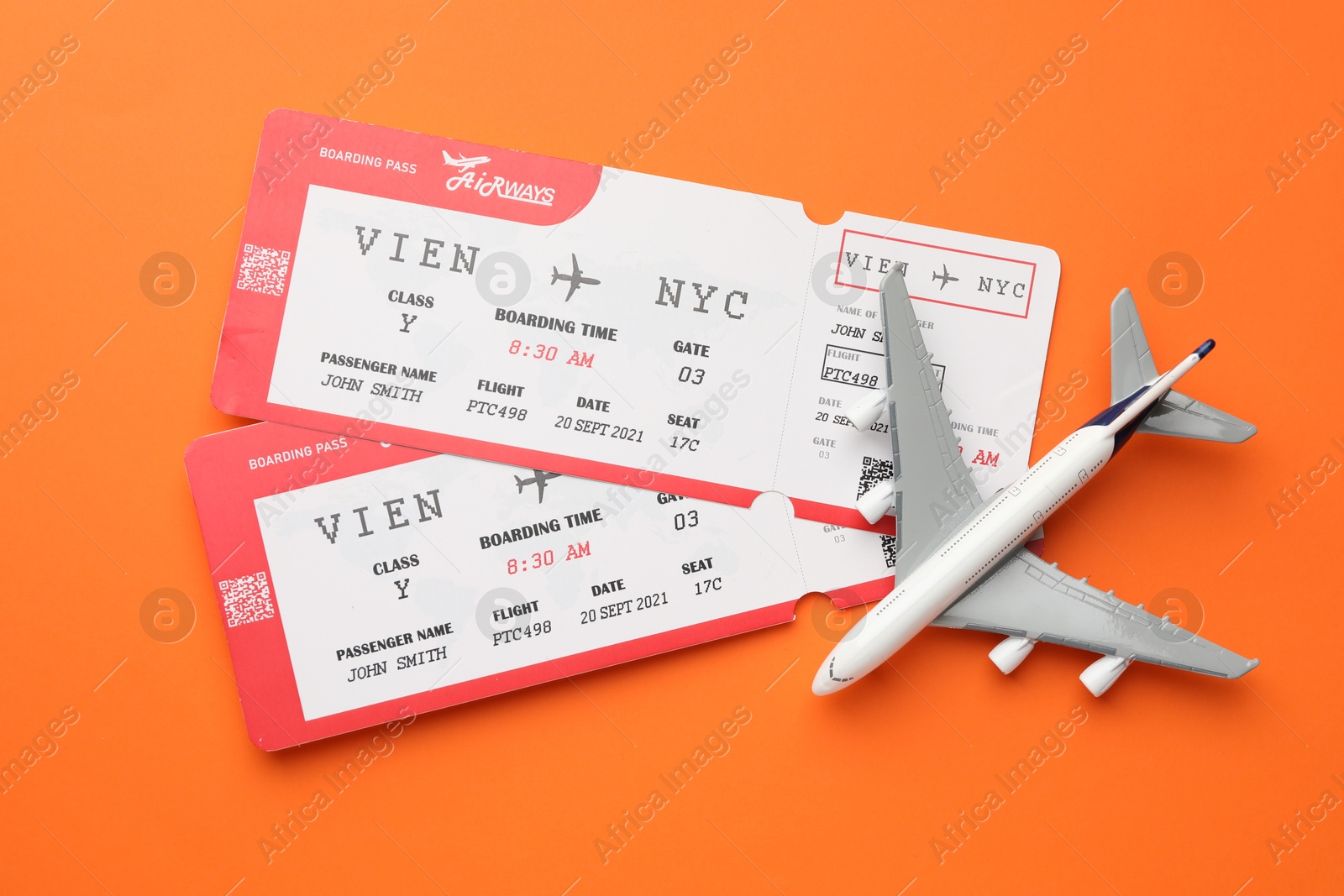 Photo of Travel agency. Flight tickets and plane model on orange background, flat lay