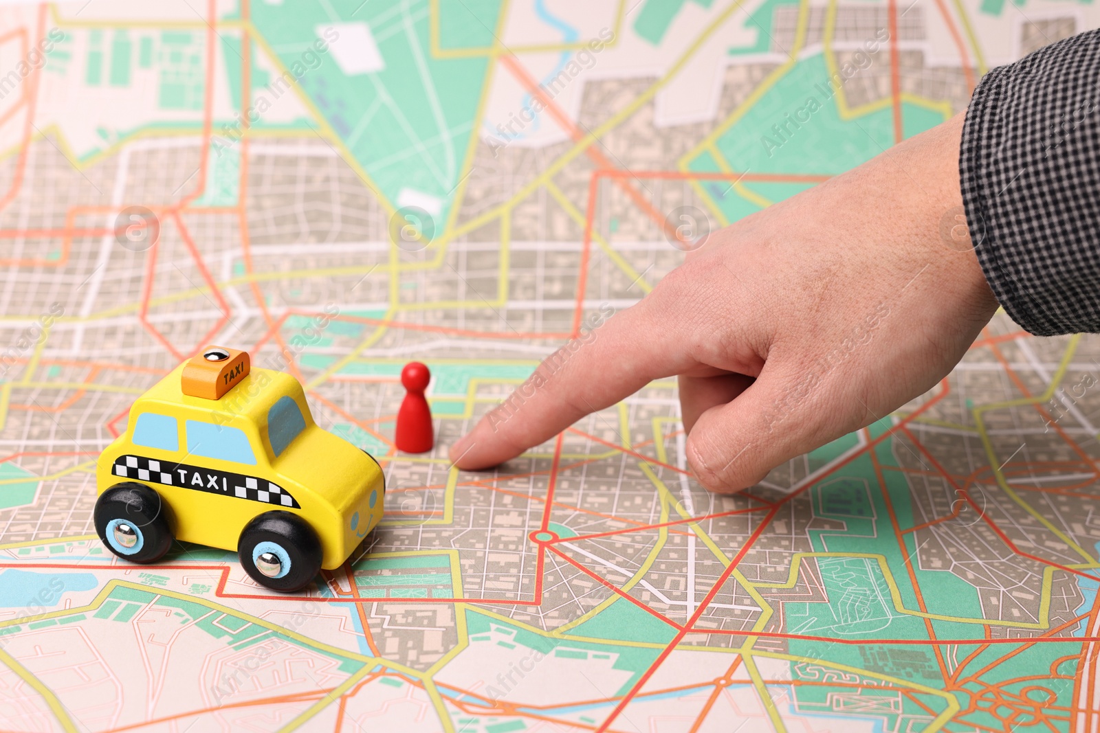 Photo of Woman pointing at city map with yellow taxi car and human figure, closeup