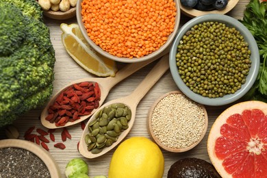 Photo of Different superfood products on wooden table, flat lay