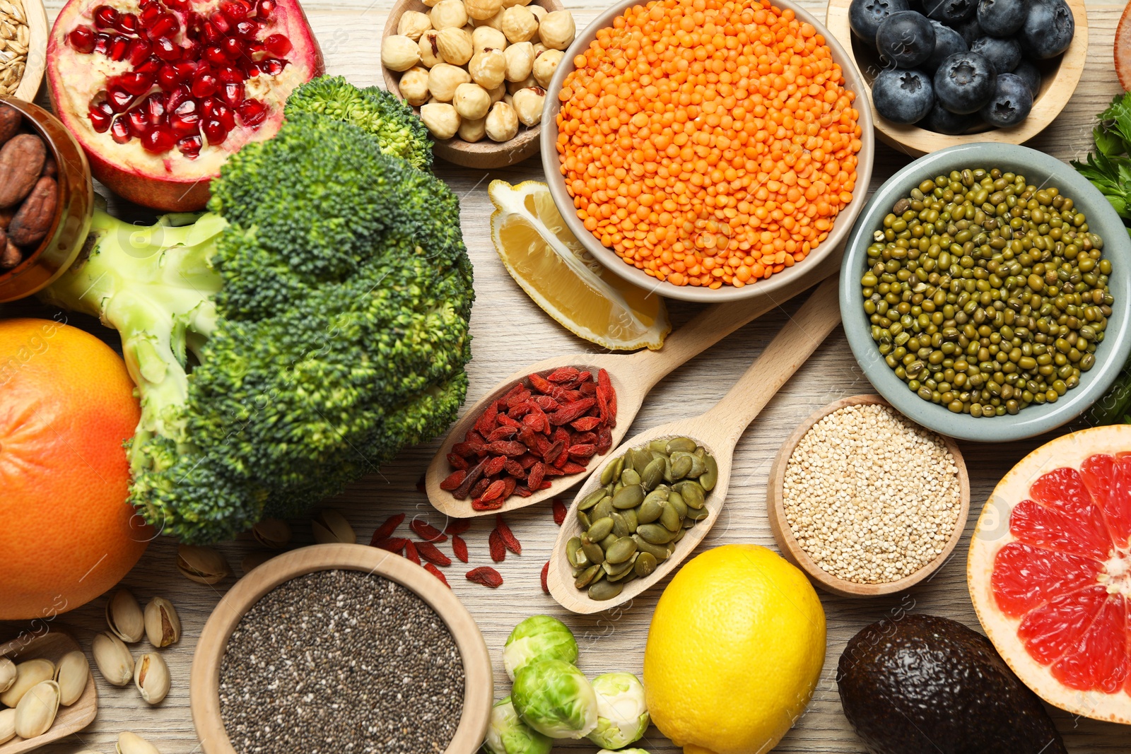 Photo of Different superfood products on wooden table, flat lay