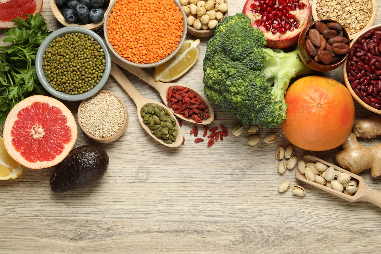 Photo of Different superfood products on wooden table, flat lay. Space for text