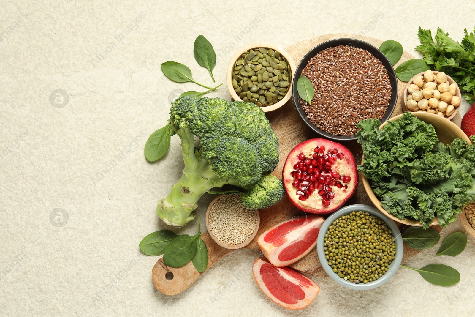 Photo of Different superfood products on light table, top view. Space for text