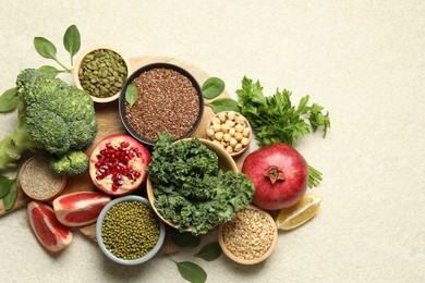 Photo of Different superfood products on light table, top view. Space for text