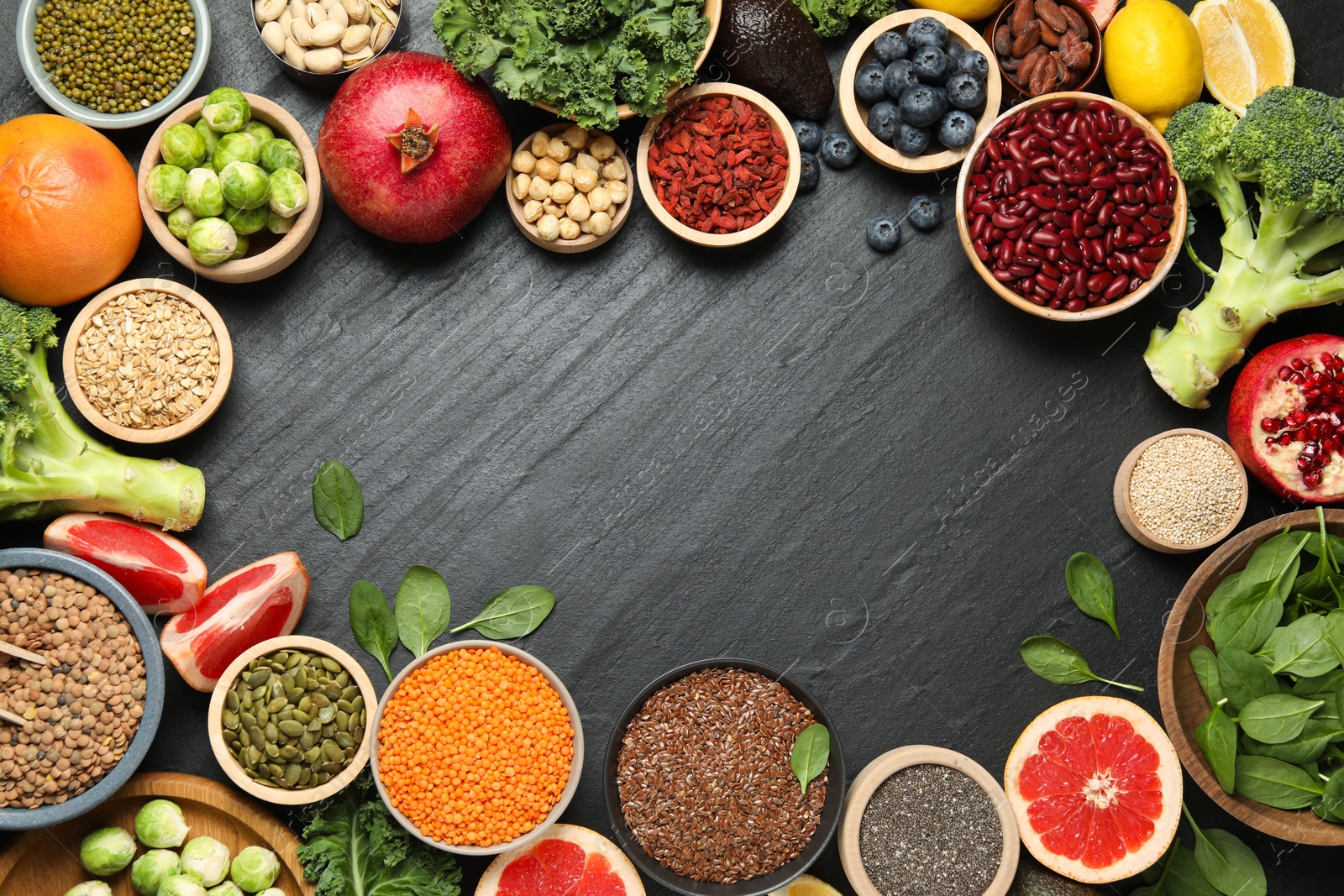 Photo of Frame of different superfood products on black table, flat lay. Space for text