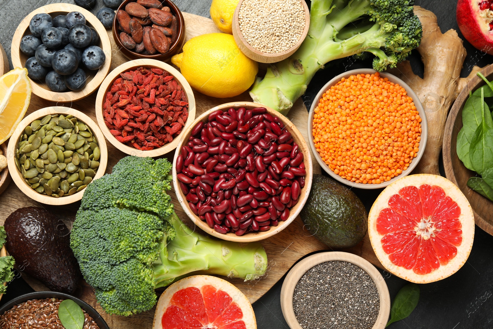 Photo of Different superfood products on black table, flat lay