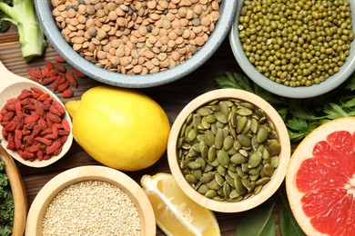 Photo of Different superfood products on wooden table, flat lay