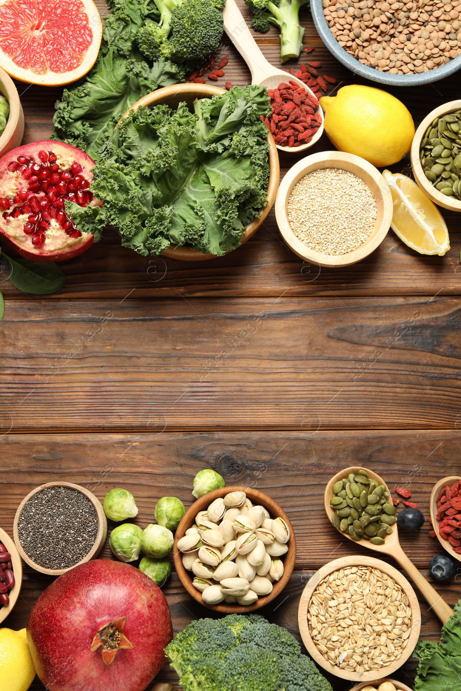 Photo of Different superfood products on wooden table, flat lay. Space for text