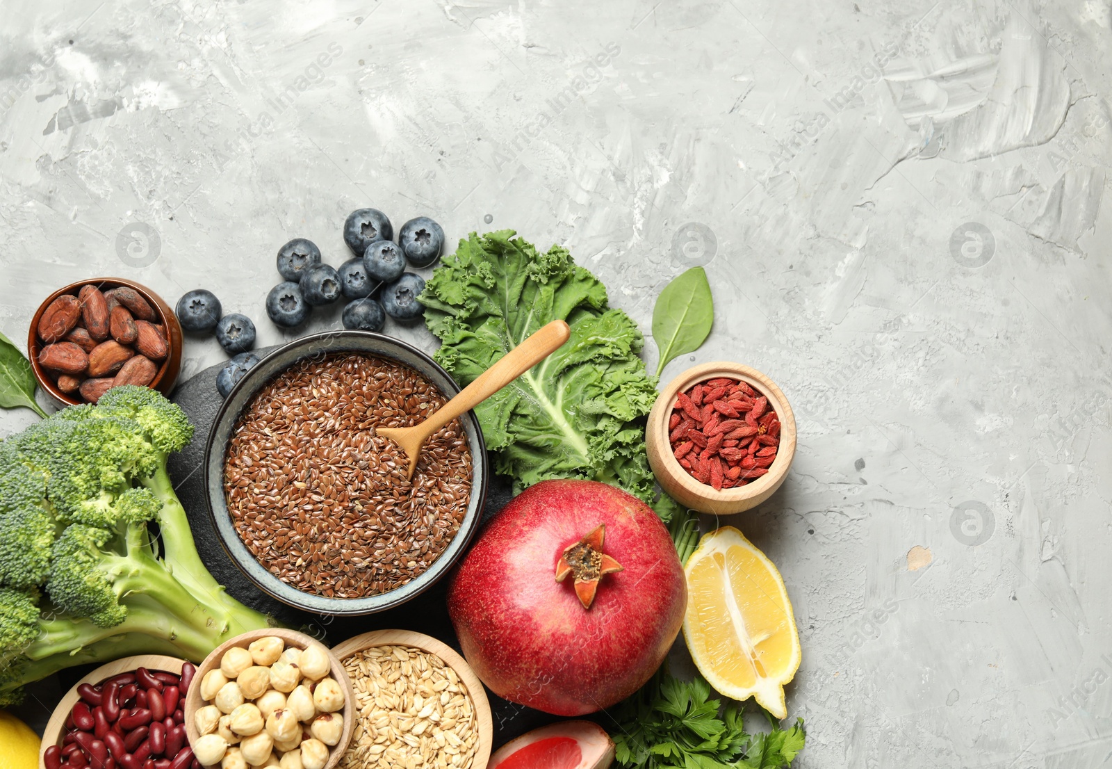 Photo of Different superfood products on grey table, flat lay. Space for text