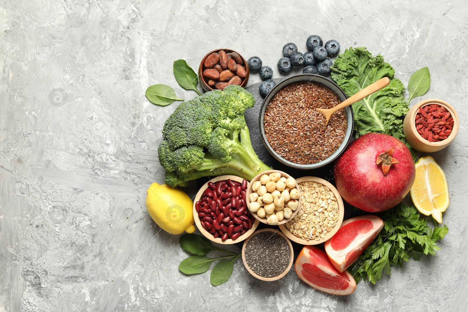 Photo of Different superfood products on grey table, flat lay