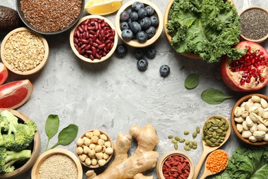 Photo of Frame of different superfood products on grey table, flat lay. Space for text