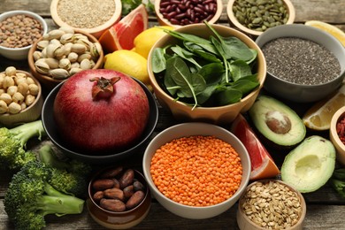 Photo of Different superfood products on wooden table, closeup