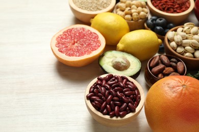 Photo of Different superfood products on white table, closeup