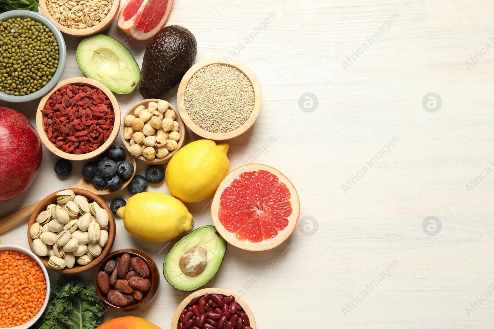 Photo of Different superfood products on white table, flat lay. Space for text