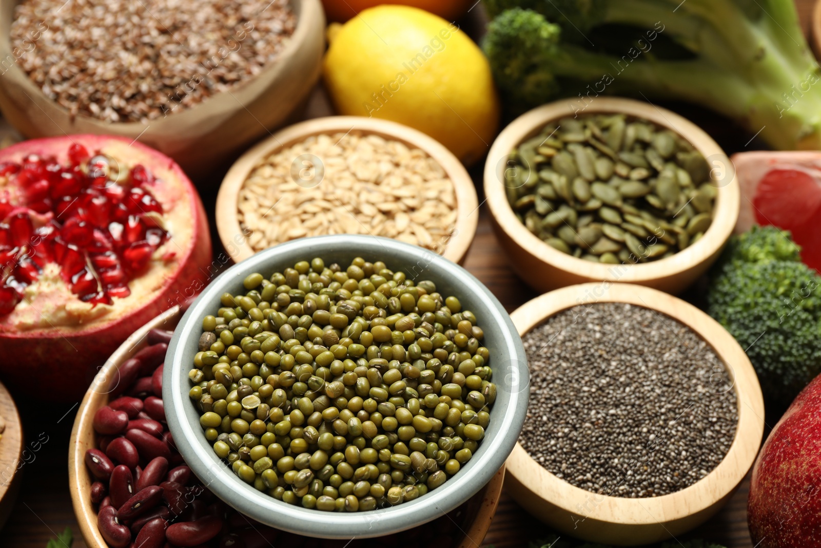 Photo of Different superfood products on wooden table, closeup