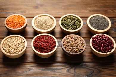 Photo of Different superfood products in bowls on wooden table