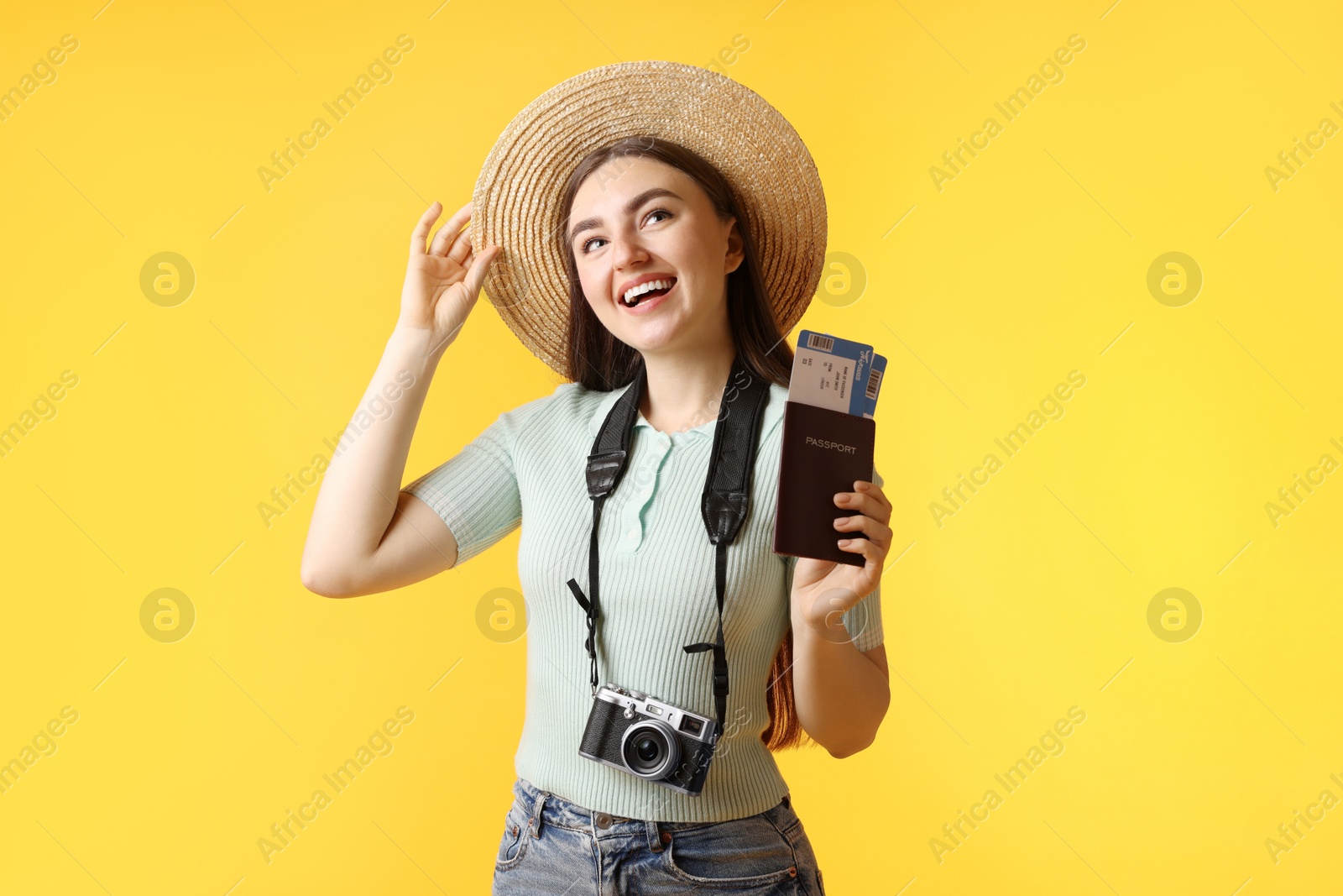 Photo of Woman with tickets, passport and vintage camera on orange background