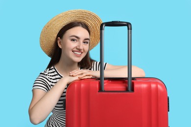 Photo of Woman in straw hat with suitcase on light blue background