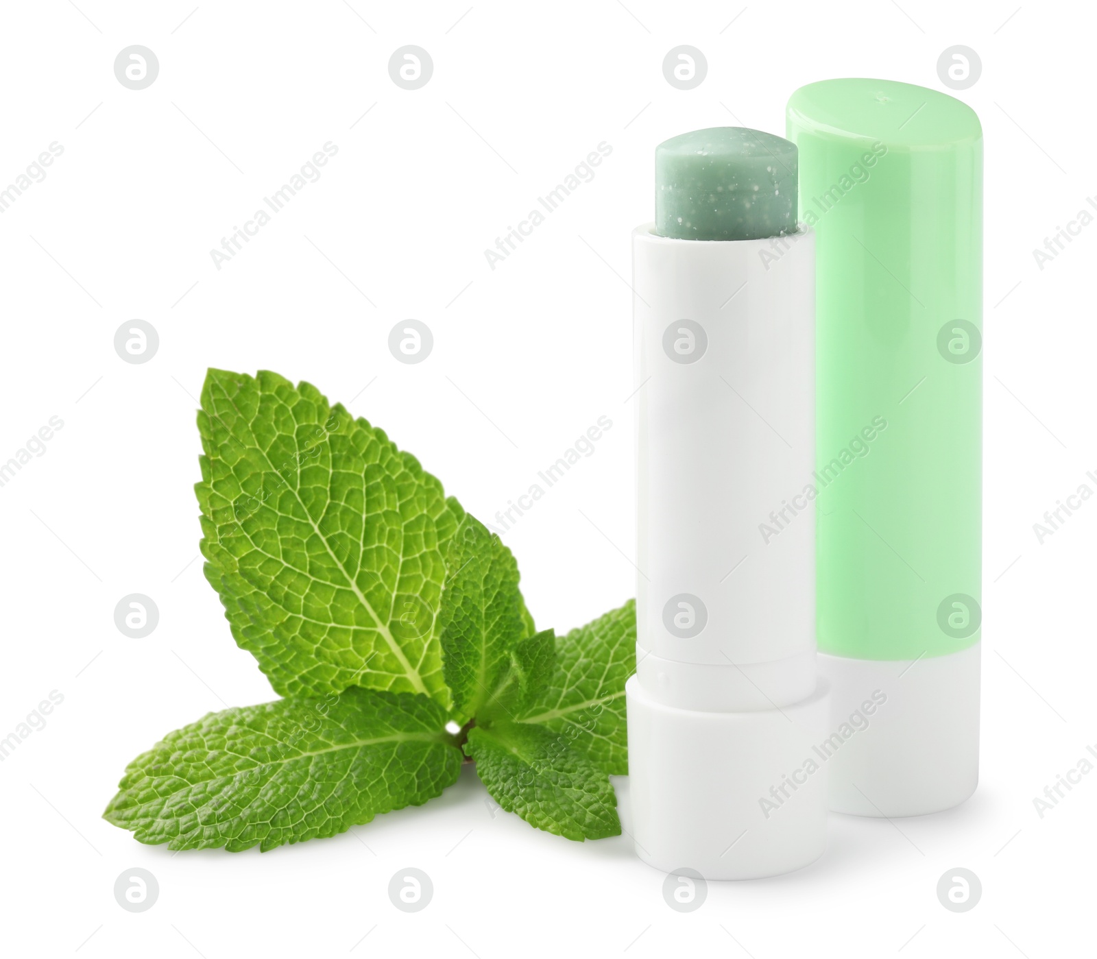 Photo of Mint lip balms and green leaves isolated on white. Cosmetic product