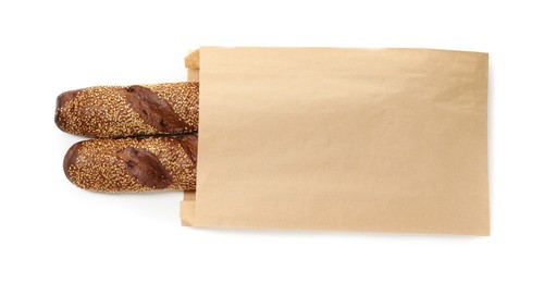 Photo of Fresh baguettes with sesame in paper bag isolated on white, top view