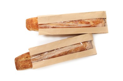 Photo of Fresh baguettes in paper bags isolated on white, top view