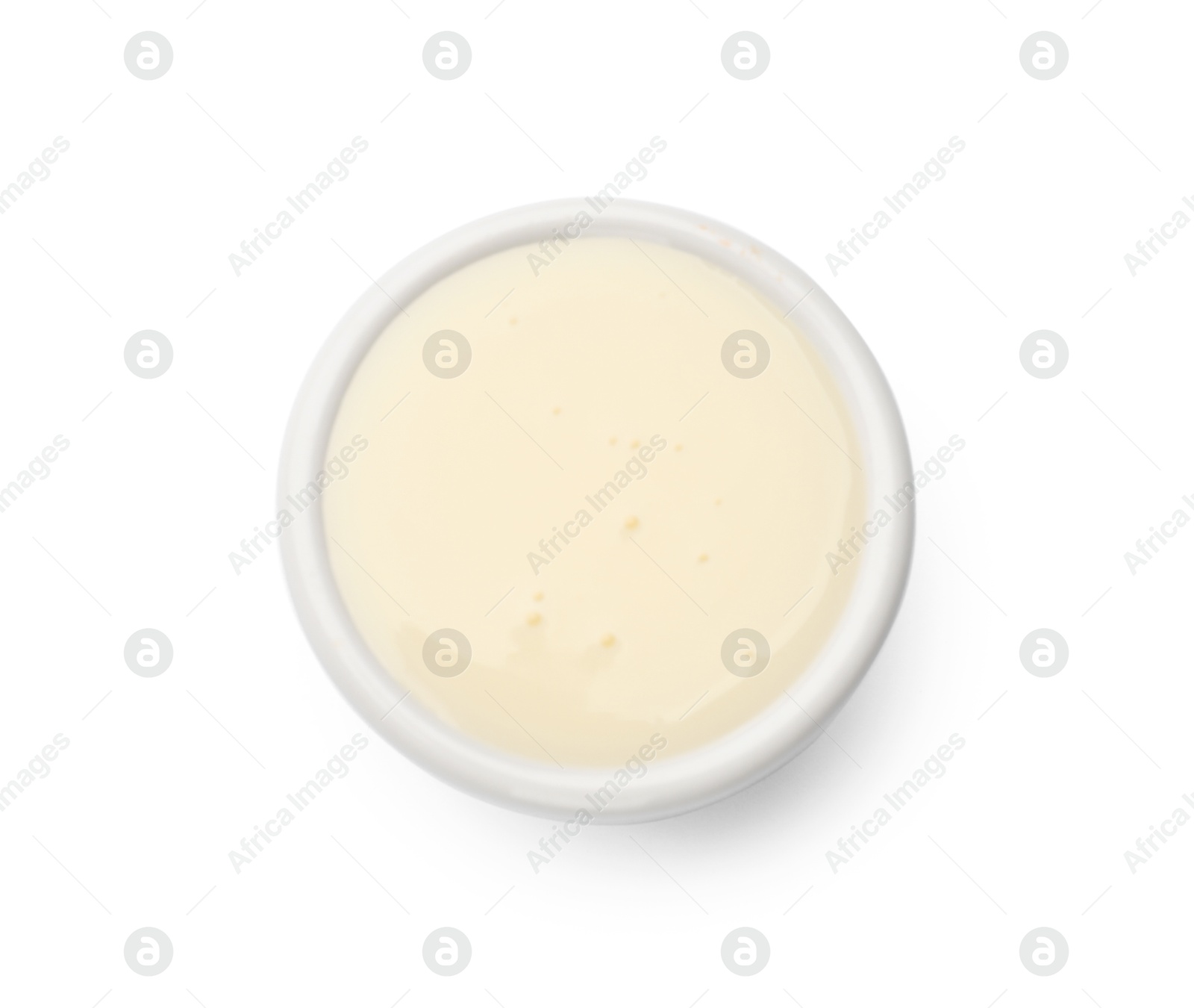 Photo of Condensed milk in bowl isolated on white, top view