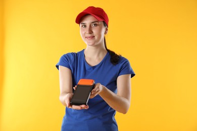 Courier with payment terminal on yellow background