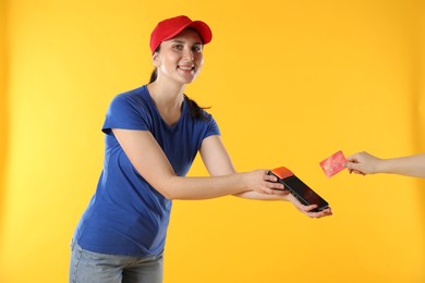 Courier taking payment from client via terminal on yellow background