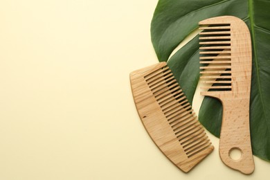 Photo of Wooden combs and monstera leaf on beige background, flat lay. Space for text