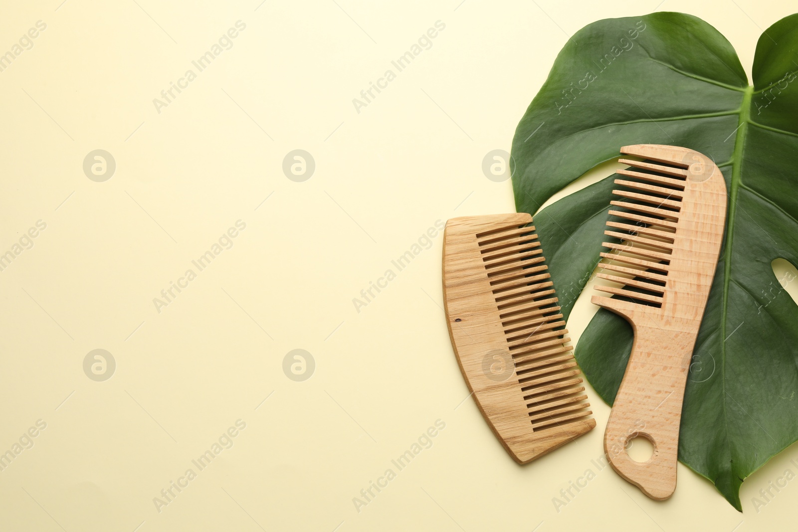 Photo of Wooden combs and monstera leaf on beige background, flat lay. Space for text