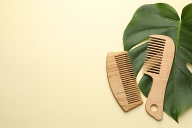 Photo of Wooden combs and monstera leaf on beige background, flat lay. Space for text