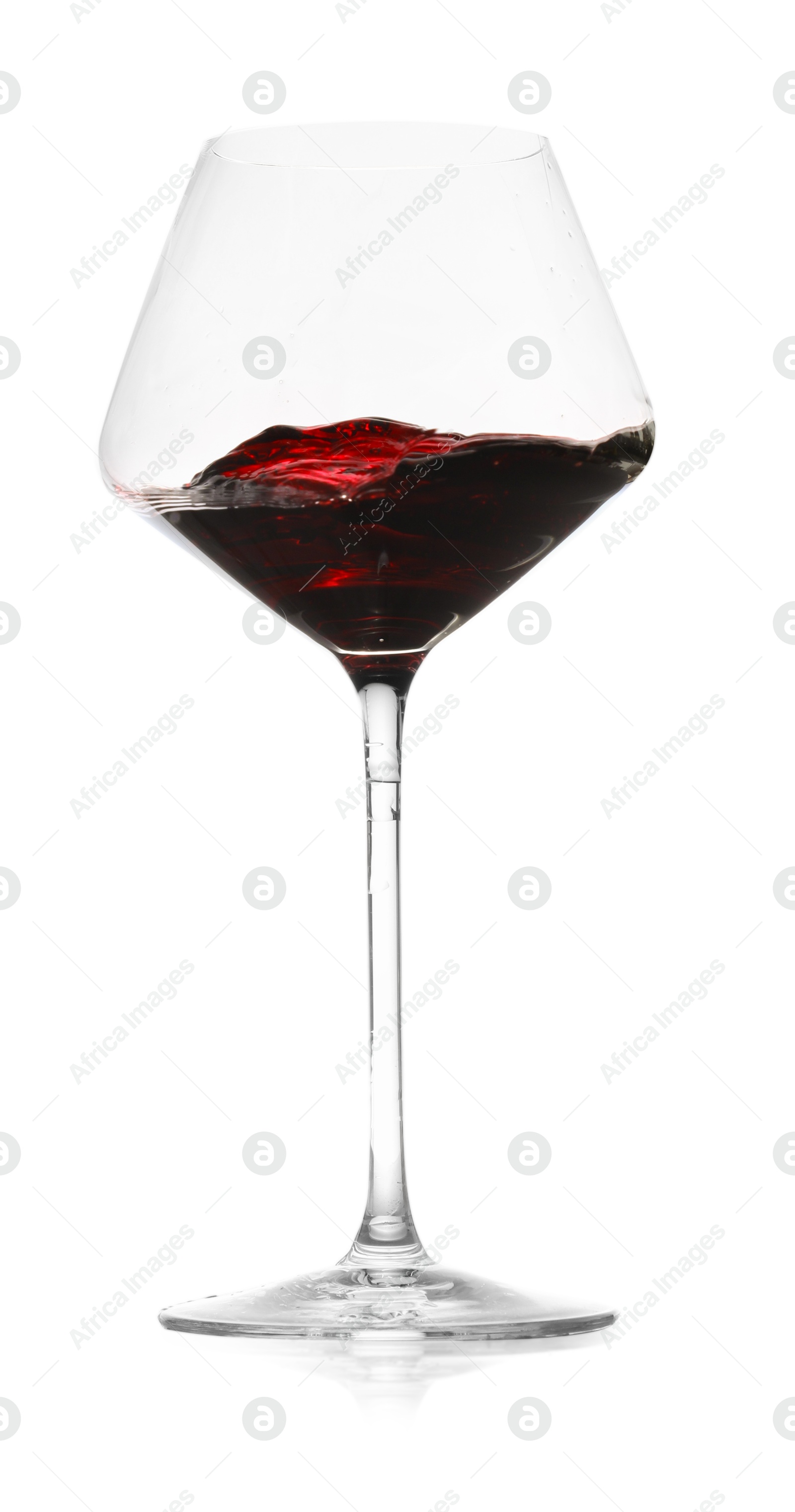 Photo of Red wine splashing in glass on white background