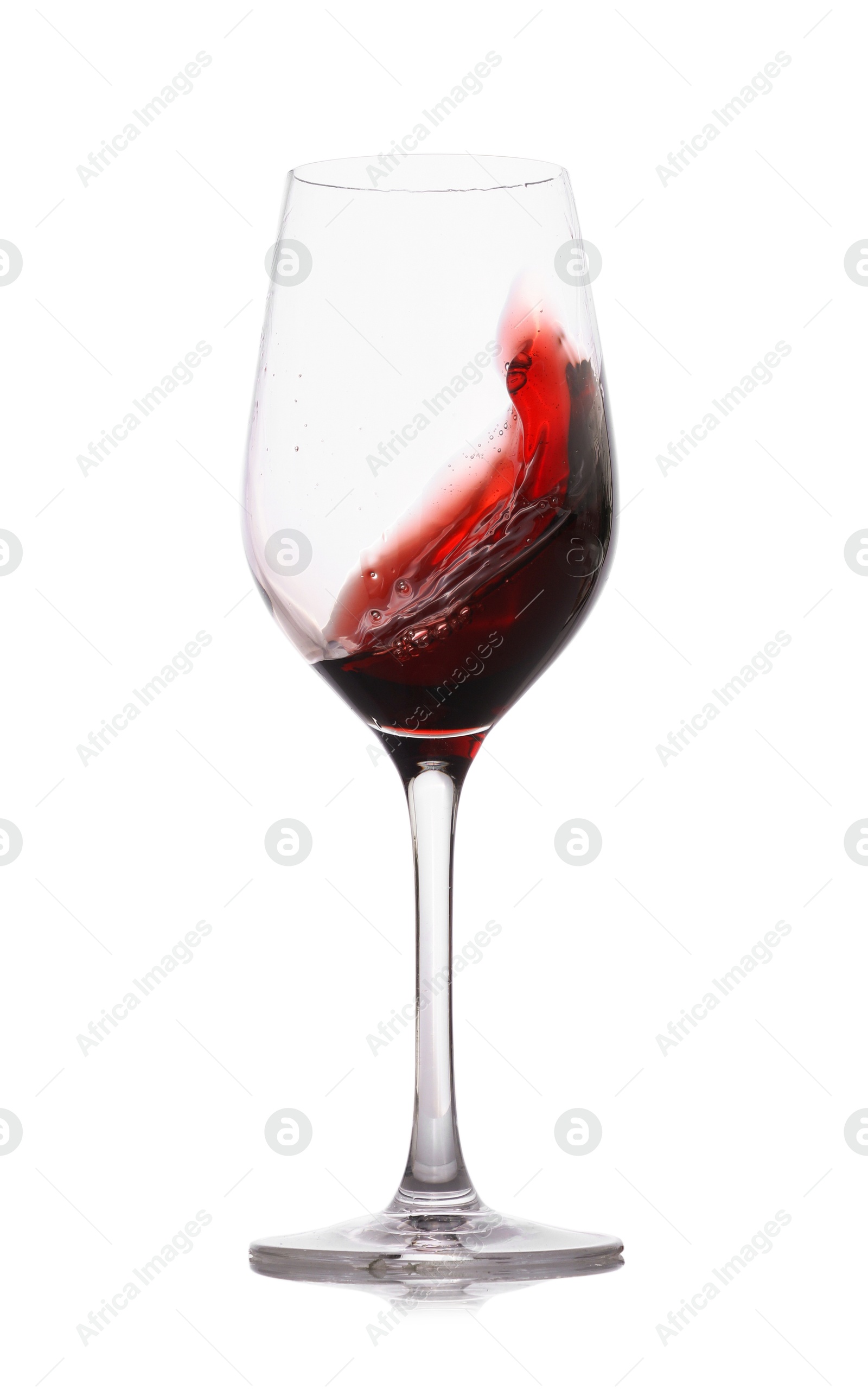 Photo of Red wine splashing in glass on white background