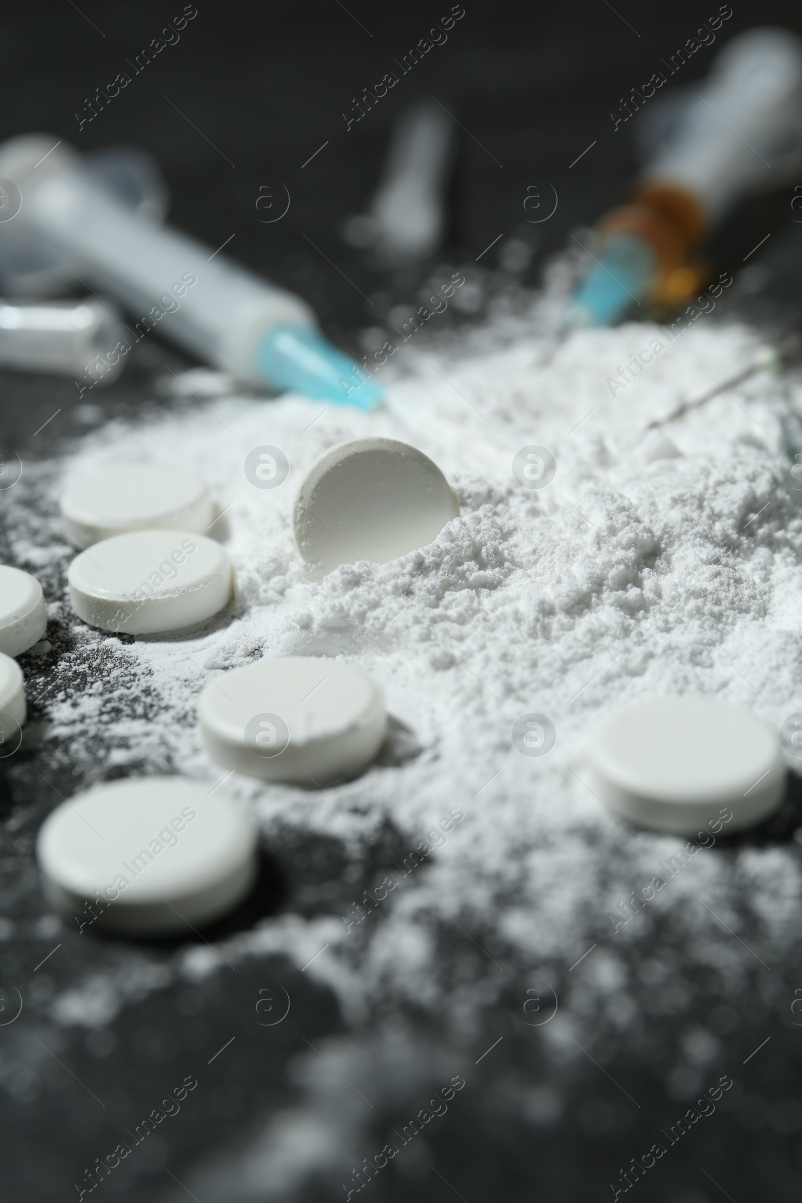 Photo of Drug addiction. Powder, pills and syringes on gray table, closeup