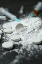 Photo of Drug addiction. Powder, pills and syringes on gray table, closeup