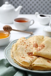 Photo of Delicious crepes served on white table, closeup