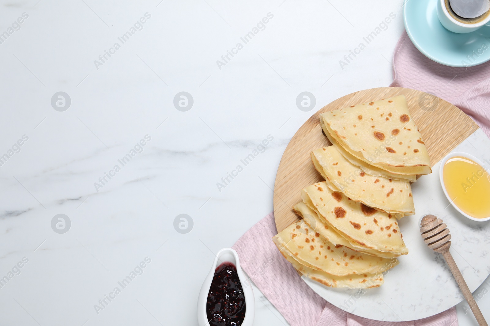 Photo of Delicious crepes served on white marble table, flat lay. Space for text