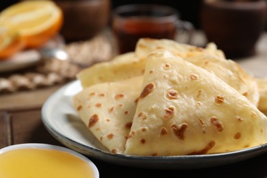 Photo of Delicious crepes and honey on table, closeup