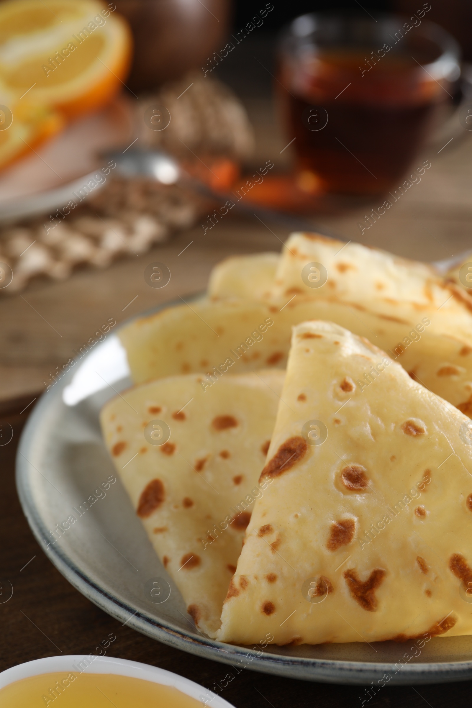 Photo of Plate with delicious folded crepes on table, closeup