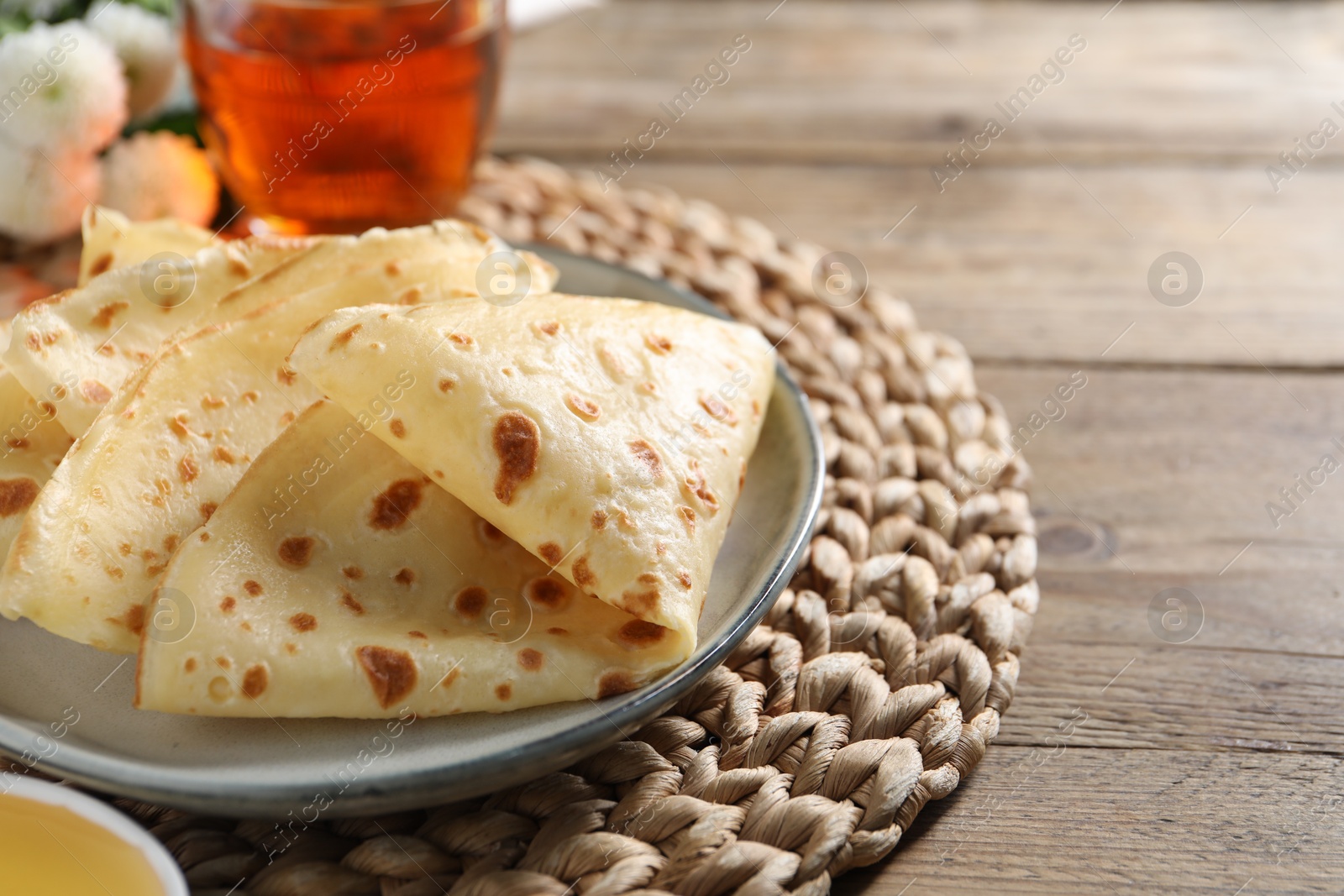 Photo of Delicious crepes on wooden table, closeup. Space for text